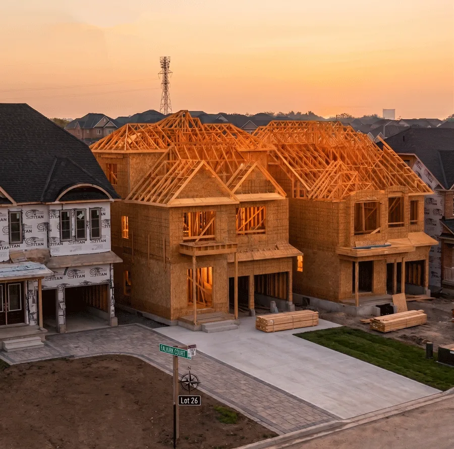 Casas en construccion al atardecer, con la estructura de madera levantada y lista para cerrar